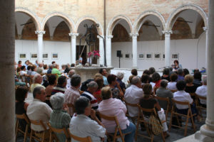 Il chiostro durante un incontro culturale. Alle pareti mostra fotografica di case coloniche.